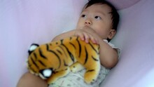 Baby Boy Hug The Tiger Toy And Prepare Sleep At Swing