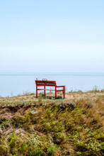 Red Bench On The Sea Coast Cliff