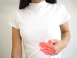 Enlarged spleen in women. She touched her chest and experienced pain and suffering. health care concept. closeup photo, blurred.