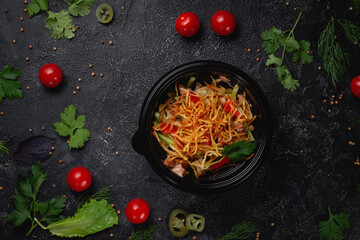 Wall Mural - Delicious salad with tomatoes, roasted potatoes, tomatoes and fresh herbs, a fresh salad on the menu of a fast food restaurant on a dark stone table. Healthy option of fast food..