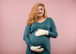 © rubchikova - Pregnant woman in a woolen mittens  holds her belly