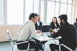 © xartproduction - Group of young business people working and communicating while sitting at the office desk together with colleagues sitting. business meeting