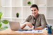 © Daenin - confident young businessman Work from home with laptop and documents on the desk.