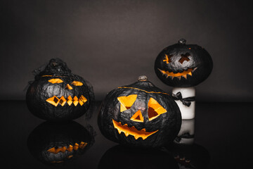 Canvas Print - carved and dark halloween pumpkins on black background