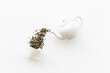 Tea concept with white teapot and dry tea leaves