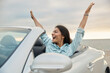 Pleased girl enjoying freedom in cabriolet car