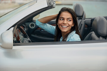 Wall Mural - European girl riding in cabriolet automobile