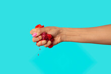 Hand Squeezing Red Berries