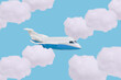 Airplane and clouds on a blue background. The plane flying through the clouds.