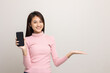 © Chanakon - Pretty young asian woman showing screen of smartphone and palm up hand holding something standing on isolated white background. She very happy.