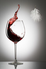 Poster - Splashes of red wine in an elegant wine glass