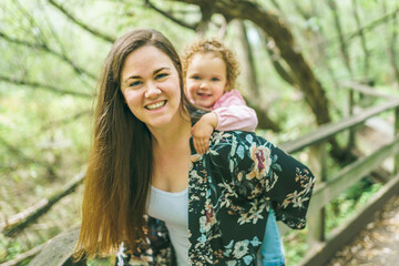 nice mother having fun in summer forest with his child girl