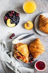 Wall Mural - Croissant sandwiches with nectarine, cherry and ricotta or cream cheese in a plate with orange juice for tasty breakfast. Top view.