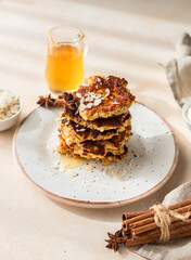 Wall Mural - Stack of delicious apple pancakes or fritters with honey, spices and almond. Sunny morning. Autumn breakfast.