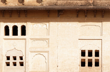 Poster - Architectural detail of geometric windows and arched niches on the walls of an ancient monument in Orchha in Madhya Pradesh, India.