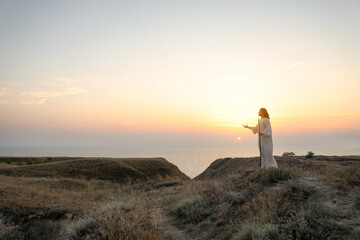 Wall Mural - Jesus Christ on hills at sunset. Space for text