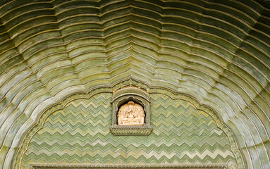 Wall Mural - Details on a beautiful green arched doorway with ornate carvings at the ancient City Palace in the city of Jaipur