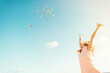 © Anna Reynal/Stocksy - Woman throwing flower petals