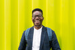 © Mihajlo Ckovric/Stocksy - Cheerful outdoor portrait of a young black male against yellow background