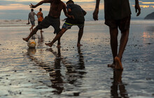 Man Dribbles Soccer Ball During Beach Football Game 