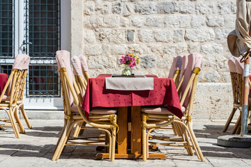 Wall Mural - Rattan chairs and table in a street restaurant