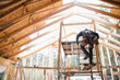 © Rob and Julia Campbell/Stocksy - Man working on the roof doing construction in winter