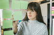 © Mihajlo Ckovric/Stocksy - Young woman writing notes on a stickers on a glass wall