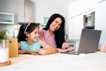 Joyful Mother Working At Home With Her Daughter