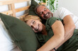 © Valentina Barreto/Stocksy - senior couple having fun lying on the bed