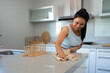 © Eloisa Ramos/Stocksy - Woman cleaning the countertop at kitchen