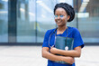 © Елена Якимова - smart black girl medical student in glasses, happy young african american woman doctor in blue uniform, stethoscope, smiling afro female nurse with crossed hands at university, college, hospital
