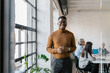© Mihajlo Ckovric/Stocksy - Portrait of a cheerful young businessman in the office