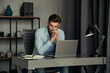 © Elena Kharichkina/Stocksy - Pensive sad man sitting in front of laptop