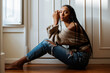 © David Prado/Stocksy - Beautiful black woman with braided long hair sitting in the floor