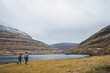 © Kike Arnaiz/Stocksy - Unrecognizable travelers walking on lake shore