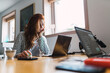 © Kike Arnaiz/Stocksy - Woman using laptop in office