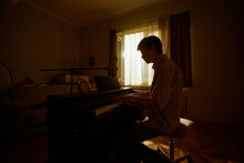 Young Man Composing On The Piano 