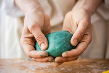 Woman Kneading Dough To Make Blue Bagels