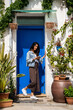 © Alba Vitta/Stocksy - happy confident woman with phone in front of house