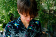 © Erin Brant/Stocksy - Teen boy in tropical shirt looking down