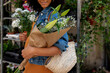 © Valentina Barreto/Stocksy - Detail of female holding flower arrangements at florist