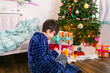 © ByLorena/Stocksy - Boy making wish near Christmas tree