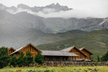 Wooden Hut With Mountains And Clouds