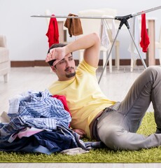 Wall Mural - Handsome man husband doing laundering at home