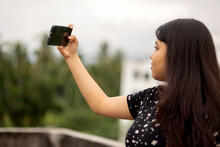 Teenage Indian Girl Taking Selfie At Outdoors