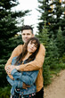 © Leah Flores/Stocksy - A Couple Affectionately Embraces in the Woods