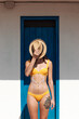 © Malquerida Studio/Stocksy - Woman in bikini with sun cream and hat