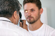 © Sean Locke/Stocksy - Exam: Doctor Uses Ophthalmoscope During Vision Test