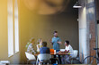 © KOTO - Lens flare over creative business people meeting at office table