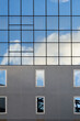 © Rowena Naylor/Stocksy - The reflection of clouds and sky on a mirrored apartment building